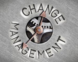 Zahnräder als Uhr mit Schriftzug Change Management kurz vor 12 
